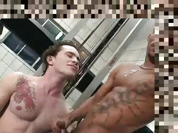 Tattooed guys in the gym cum on each other