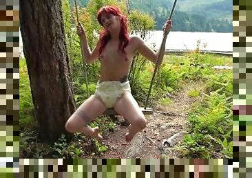 Swinging in a diaper, outdoors at the cabin