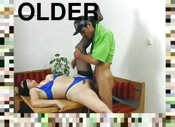 Blindfolded older lady banged on table