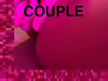 Playing with a dildo under a purple lamp