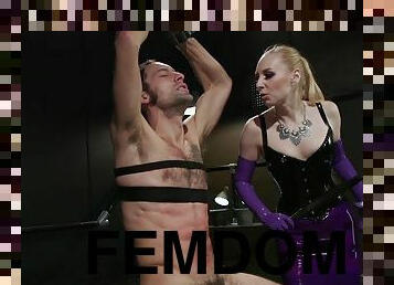 Blond Hair Lady dominatrix in latex bites male pole