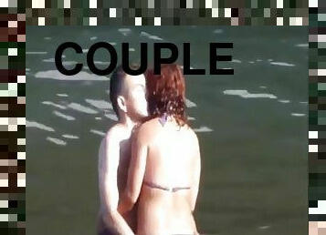 Horny couple having fun in the water at the beach