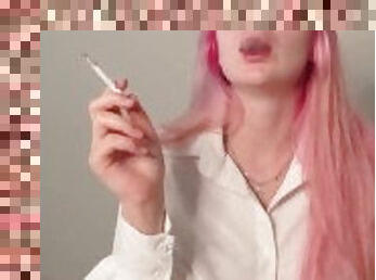 Girl with pink hair smokes a cigarette in a sexy shirt