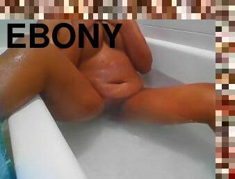Sweet Ebony girl lies in tub touching herself