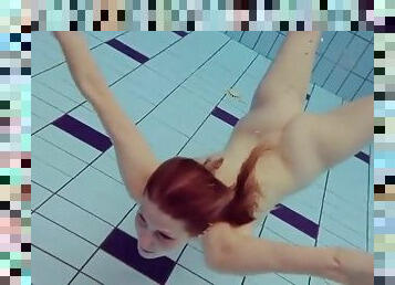 Skinny redhead swimming naked underwater