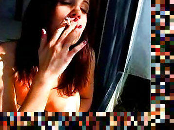 Brunette exhibits her big tits while smoking