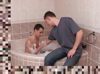 Young guys kissing in the bubble bath