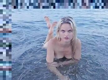 Blonde natural girl swimming naked in public beach