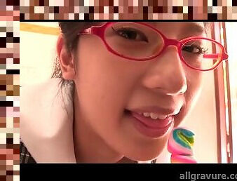 Schoolgirl in glasses licks a lollipop